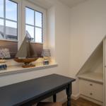 Schreibtisch unter Fenster mit Segelboot und Lampen, Schrank unter Dachschrägen