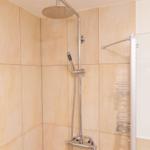 Dusche mit Duschbrause und Handbrause an Wand montiert