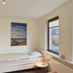 Bedroom with bed, wall art, and window view.