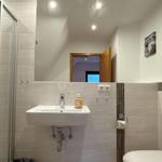 Badezimmer mit Dusche, Waschbecken und Toilette
