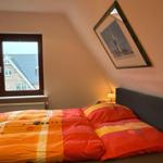 Schlafzimmer mit Doppelbett, Fenster und Wandbild.