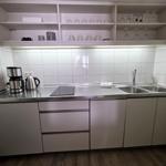 Neue Küche mit Ceranfeld, Spülmaschine, Kühlschrank mit Eisfach, Wasserkocher, Toaster und Nespressomaschine.