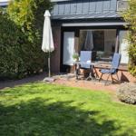Terasse vor der Tür mit Blick in einen grünen, blühenden Garten