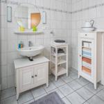 Badezimmer mit Waschbecken, Spiegel, Dusche und Handtuchregal.