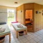 Sauna mit Holzverkleidung und zwei Liegen mit Handtüchern.