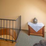 Treppenhaus mit Holzstufen, Metallgeländer und Holzschrank mit Tischdecke.