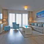Wohnzimmer mit Sofa, Sitzgelegenheit und Blick aufs Meer.