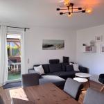 Wohnzimmer mit Sofa, Esstisch und Terrassentür.