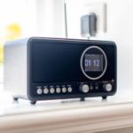 A modern radio receiver sits on a windowsill.