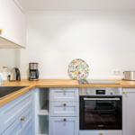 Kitchen with wooden countertop, stainless steel sink, and Bosch cooktop.