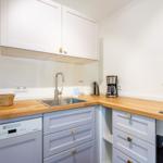 Kitchen with wooden countertops, white cabinets, and stainless steel sink.