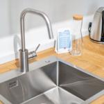 Kitchen worktop with stainless steel sink and modern faucet.
