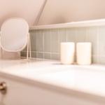 Bathroom with mirror, soap dispenser, and sink