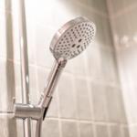 Shower head with handheld shower on tiled wall