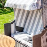 Hanging chair with striped cover and sunshade in the garden