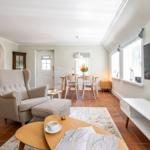 Living and dining area with armchair, table, and TV.
