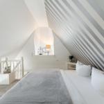 Schlafzimmer mit Dachschrägen, Bett und Fenster
