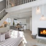Wohnzimmer mit Kamin, Sofa und Blick in die Küche