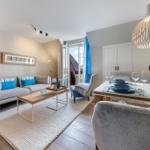 Wohn- und Essbereich mit Sofa, Tisch und moderner Beleuchtung.