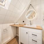 Badezimmer mit Dachschrägen, Waschbecken und Heizkörper