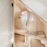 Sauna mit Holzbank und Glaswand, Dachneigung sichtbar