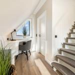 Höhenlage mit Schreibtisch, Pflanzen und Treppe zur oberen Etage.