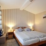 Schlafzimmer mit Doppelbett, Nachttischen und Streifenwand