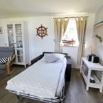 Schlafzimmer mit Bett, Küchenbereich und Wandbild