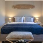 Schlafzimmer mit Bett, Nachttischen und Wanddekoration.
