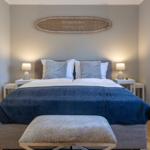 Schlafzimmer mit Bett, Nachttischen und Wanddekoration.