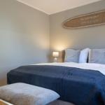 Schlafzimmer mit Bett, Nachttisch und Wanddekoration.