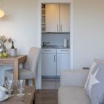 Wohnzimmer mit Sofa für zwei Personen sowie einen Sessel