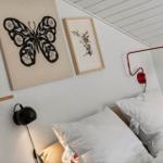 Schlafzimmer mit Bett, Wandlampen und Kunst an der Wand.