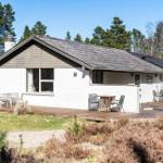 Wohnhaus mit Holzterrasse und Garten. Umgeben von Bäumen und Sträuchern.