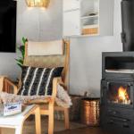 Ein Raum mit einem Sessel, Kamin und Fernseher an der Wand.