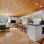 Küche mit Essbereich und Wohnzimmer unter Holzdecke.
