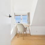 Schreibtisch mit Stuhl unter Fenster in Dachschrägenraum