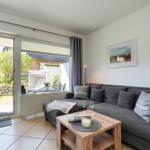 Wohnzimmer mit Sofa, Couchtisch und Blick auf den Garten.