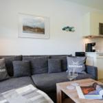 Wohnzimmer mit Sofa, Couchtisch und Küchenbereich im Hintergrund.