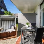Terrasse mit Liegestuhl und Tisch für zwei Personen.