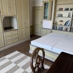 Bedroom with double bed, wardrobe, and bookshelf. Wooden floor and rug.