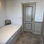 Bedroom with mattress, pillow, and door. Tile floor and wardrobe.