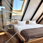 Schlafzimmer mit Dachschrägen, Dachfenster und Holzbett.