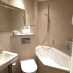 Badezimmer mit Badewanne, Dusche, WC und Waschbecken.