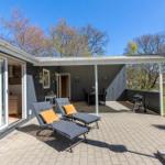 Deck with lounge chairs, grill, and umbrella. View into living area and garden.
