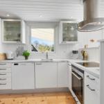 Kitchen with white cabinets, stainless steel sink, and window with view outside.