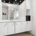 Bathroom with mirror cabinet, shower, and window with plant
