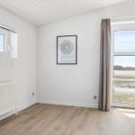 Bedroom with window, bed, and crib. Wooden floor and wall art.