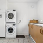Washing machine and dryer are side by side. Kitchen counter with sink and basket.
