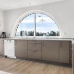 Kitchen with arched window, sink, and range hood.